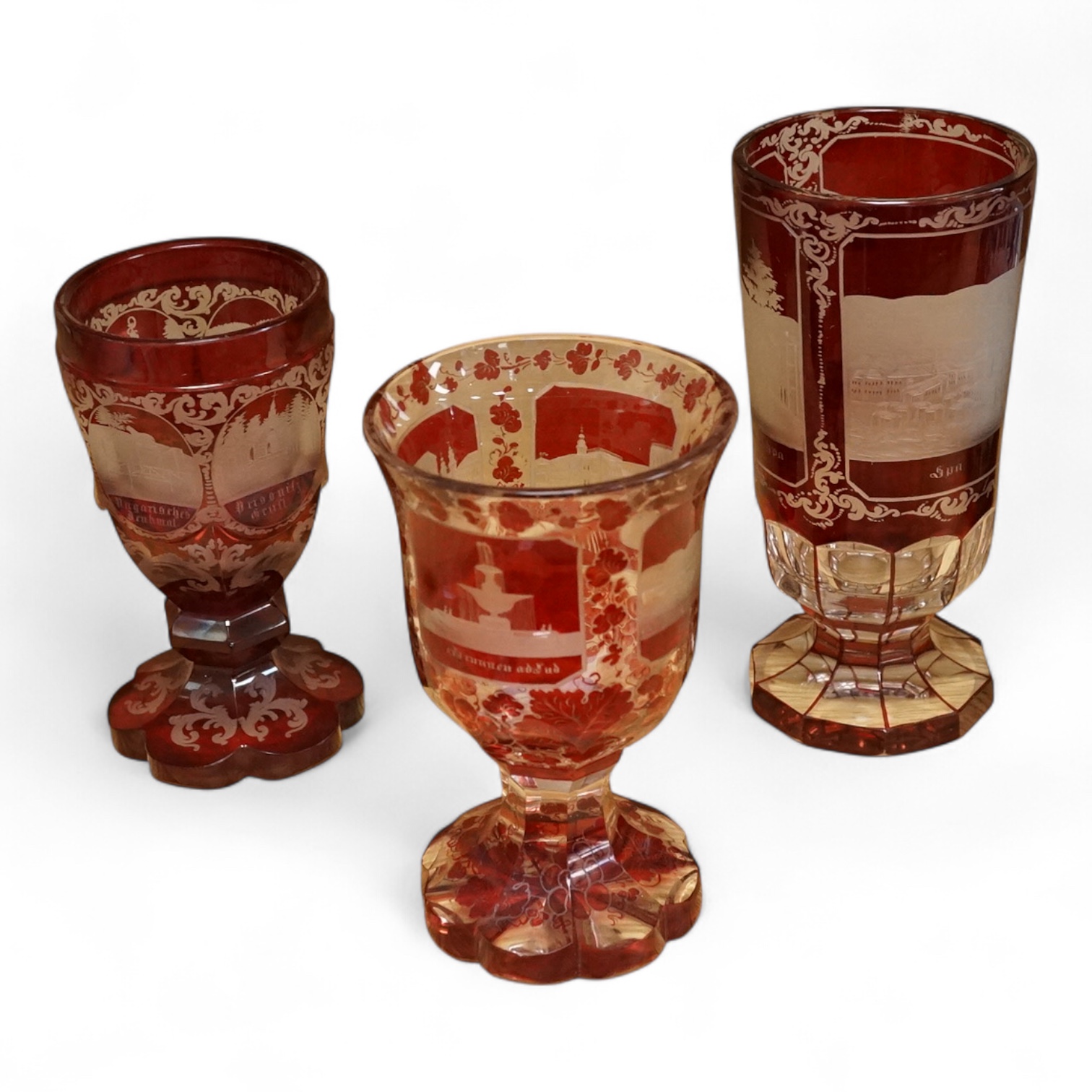 Three Bohemian topographical engraved ruby flashed spa glasses, late 19th century, largest 16cm high